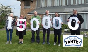 6 people holding cut-out numbers, reading 150,000