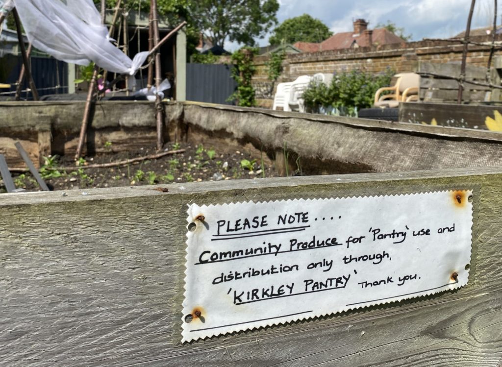 A sign on a raised bed at Kirkley Pantry Community Garden, saying produce is for use in the Pantry