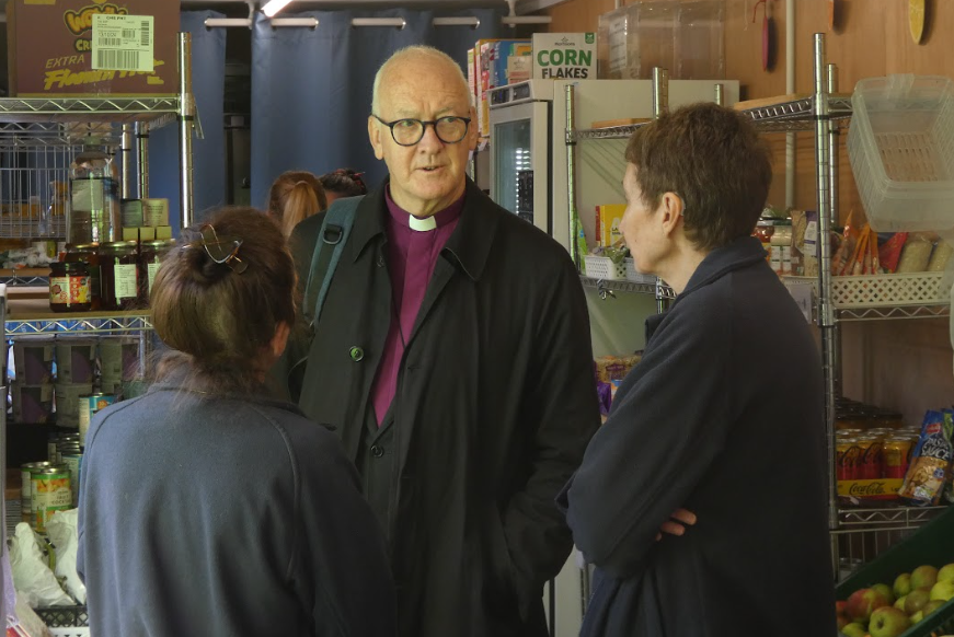 The Bishop of Leeds chats to a volunteer, inside InterAct Pantry