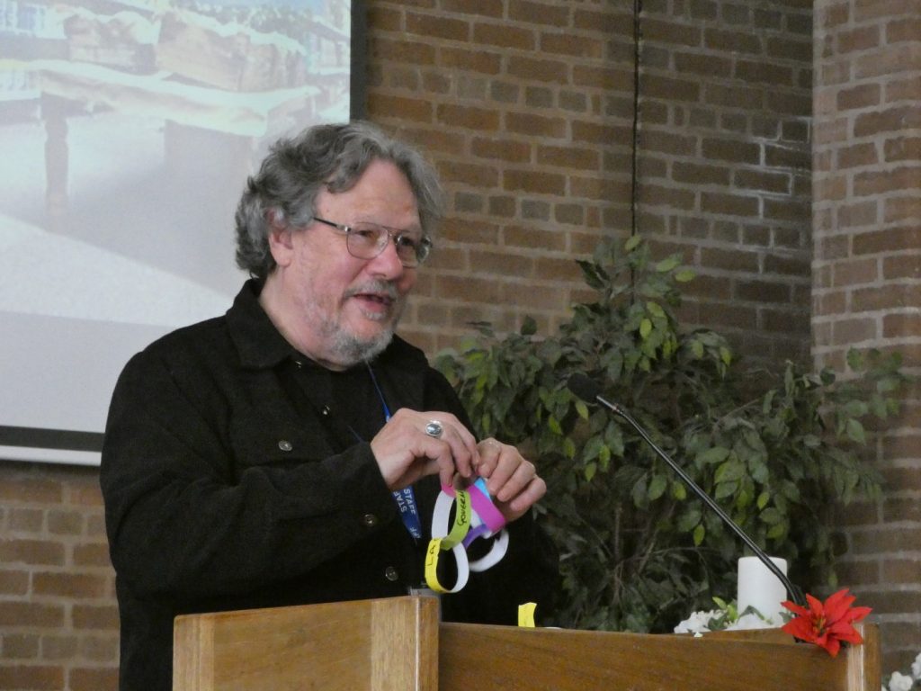 Chris Shelley pulls apart a paper chain at the Your Local Pantry conference in Bootle, Merseyside
