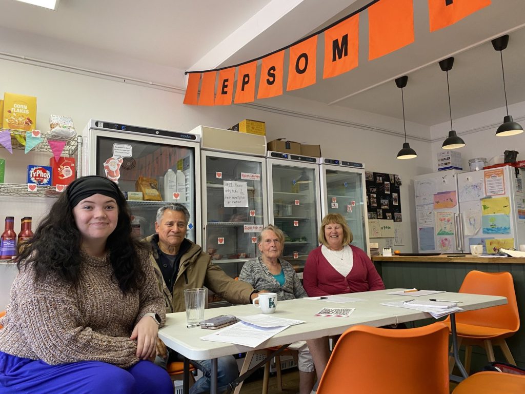 Four people sitting at a table inside Epsom Pantry
