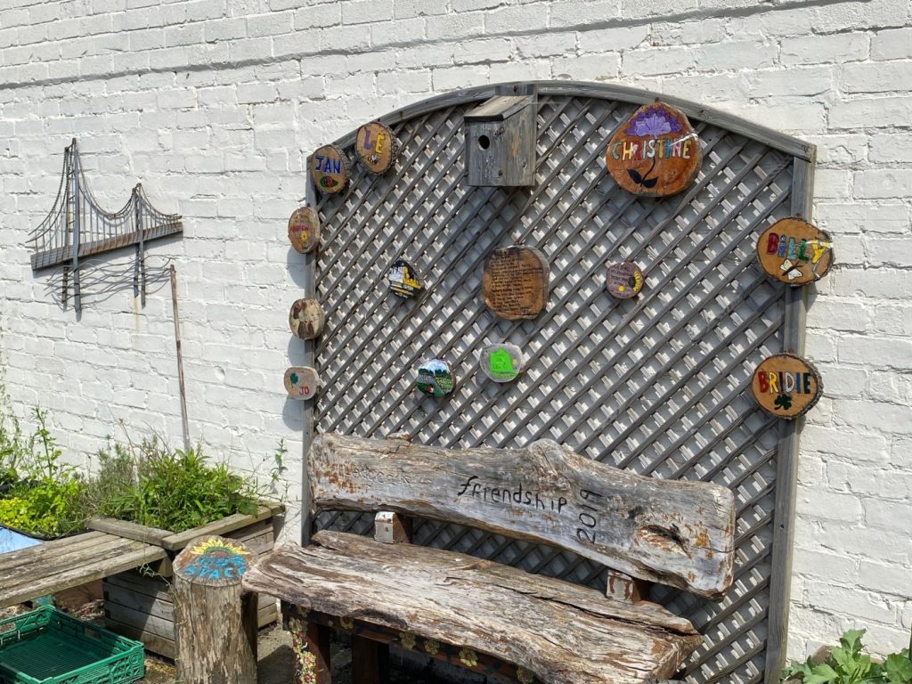 A bench and trellis with named plaques on