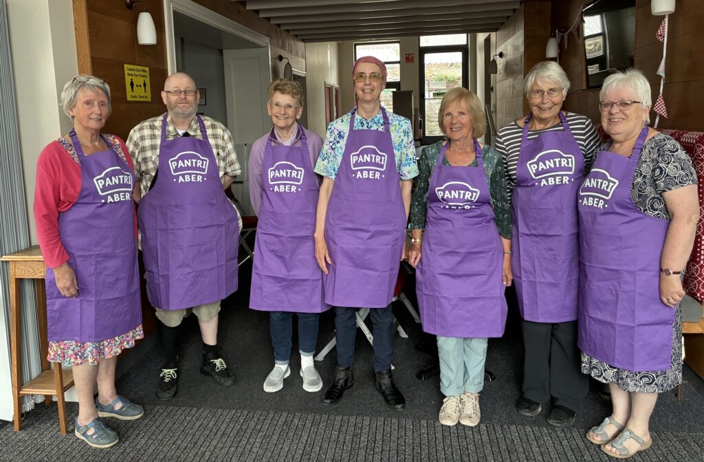 A group of people in purple Pantry aprons