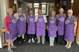 A group of people in purple Pantry aprons